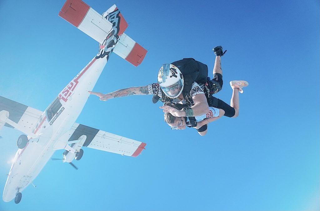 Une des activités à faire à Dubai, le saut en parachute. Saut de deux personnes dans le vide avec l’avion au dessus d’eux